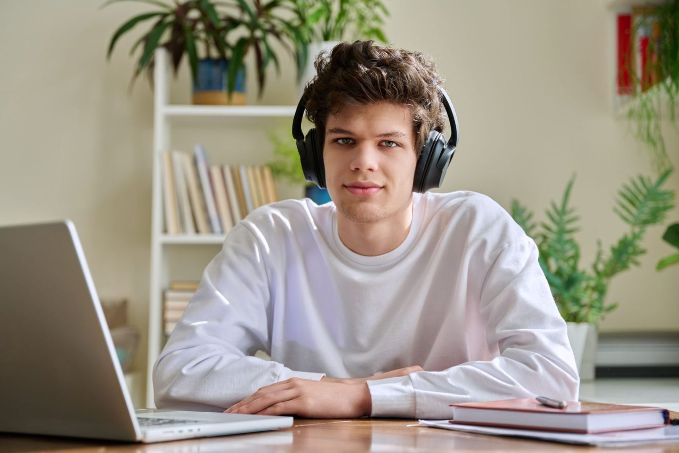A young adult wearing headphones at a desk