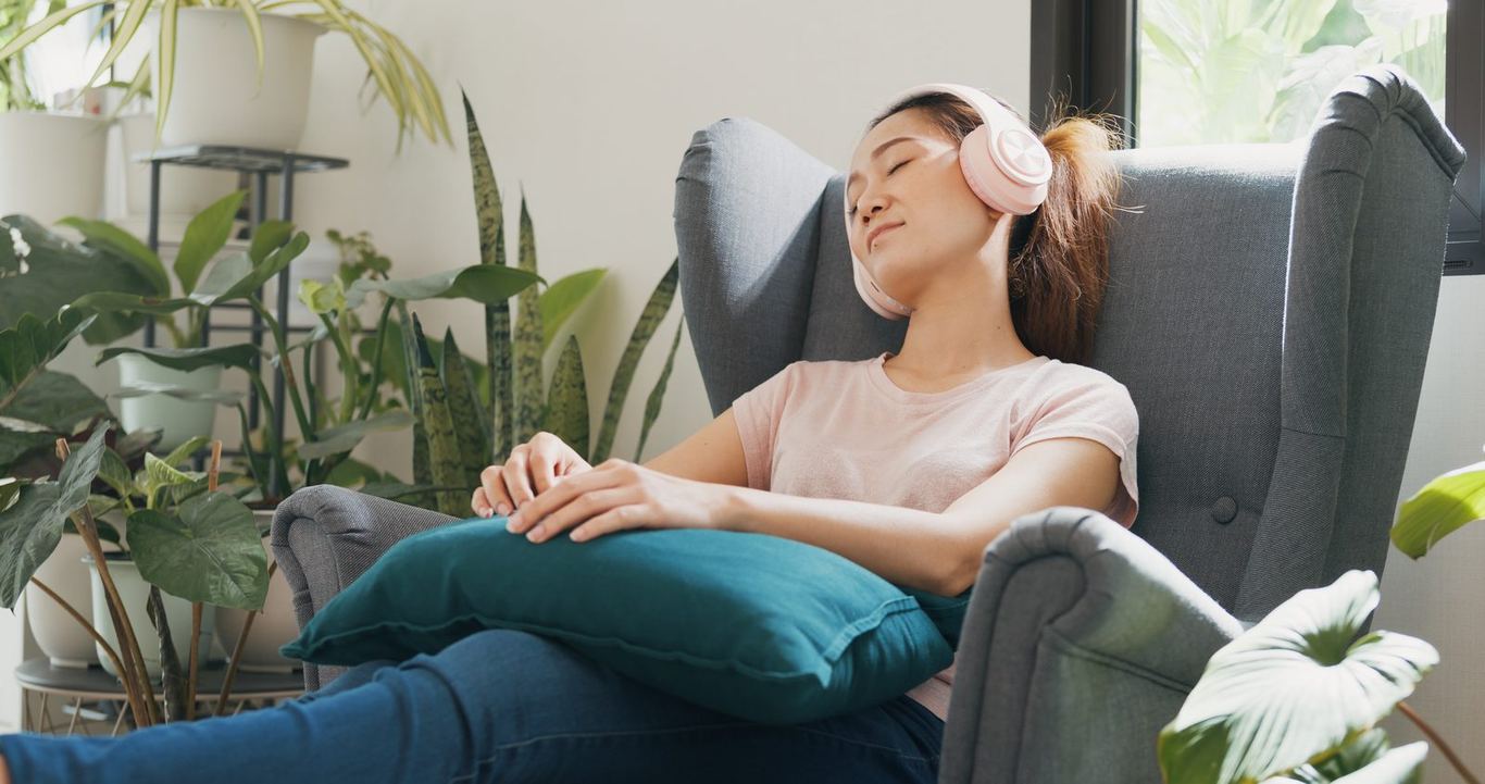 A person relaxing in an armchair with headphones