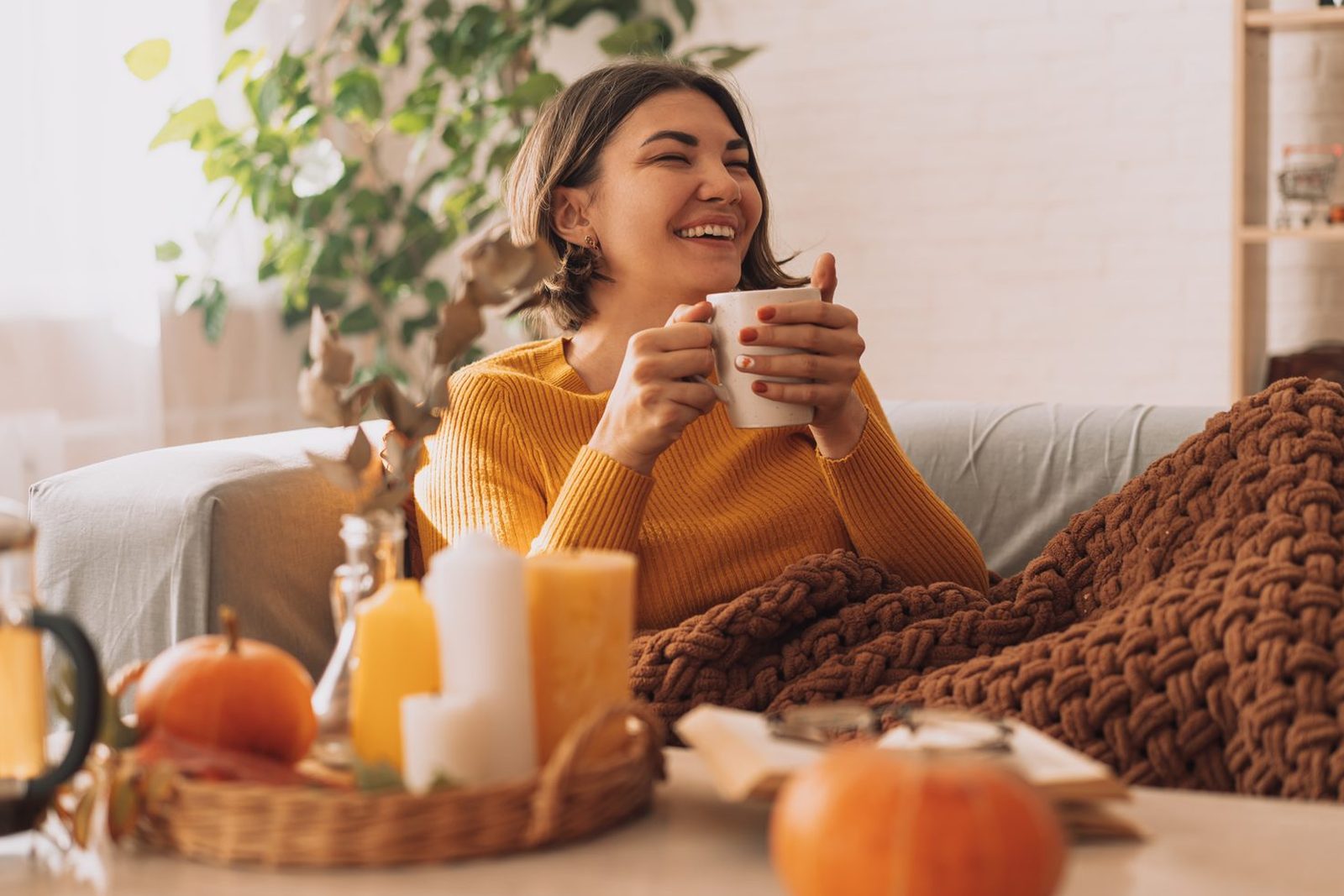 Woman with a warm drink enjoying an autumn day at home